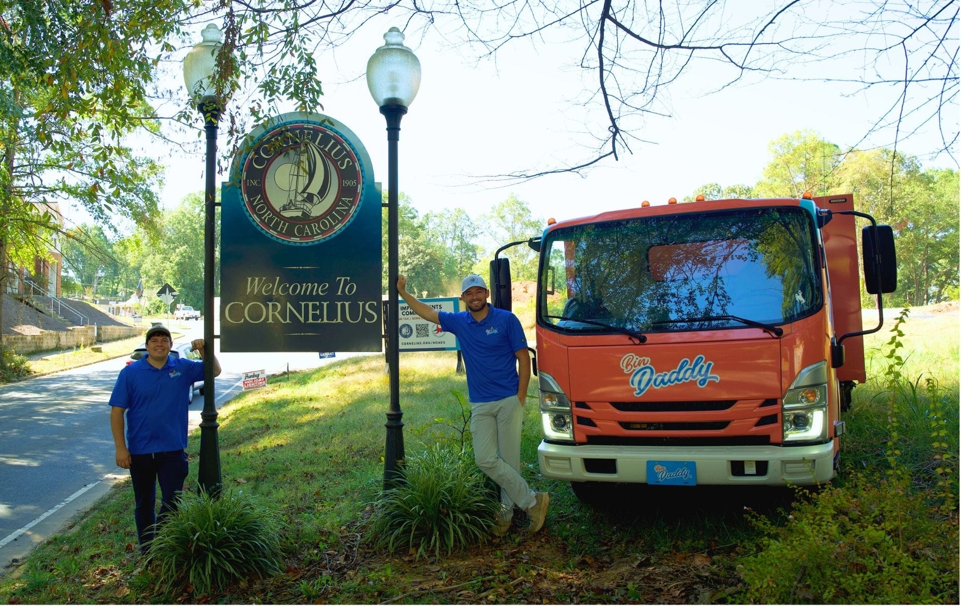 Bin Daddy trash bin cleaning truck and team by Welcome to Cornelius NC sign