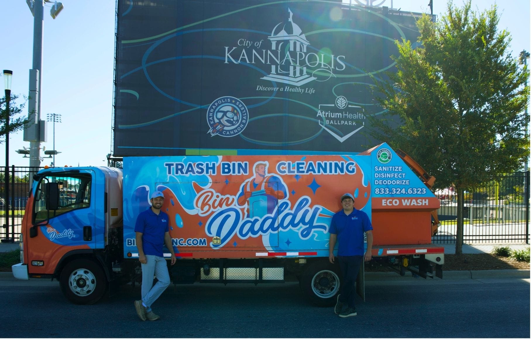 Bin Daddy trash bin cleaning truck and team by Welcome to Kannapolis NC sign