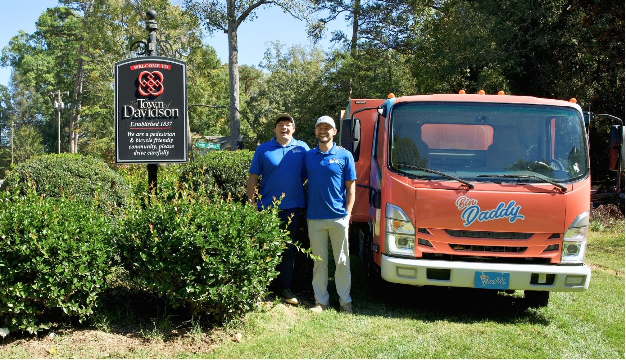 Bin Daddy trash bin cleaning truck and team by Welcome to Davidson NC sign