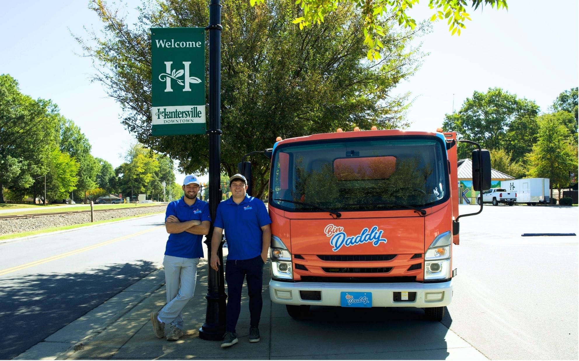 Bin Daddy trash bin cleaning truck and team by Welcome to Huntersville NC sign